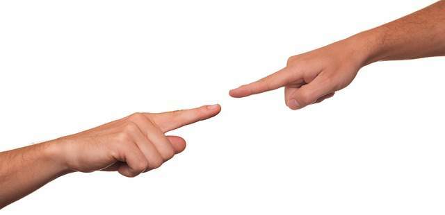 Zwei Finger die aufeinander zeigen und sich fast berühren