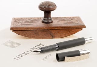 Eine Notarurkunde auf weißgelbem Papier mit Stempel und Füller darauf liegend