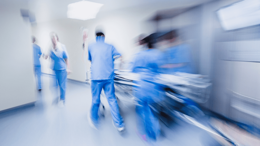 Verschwommenes Bild eines Klinikflurs mit Pflegern.